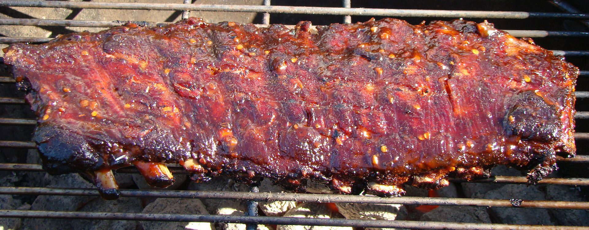 Glazed pork ribs on a grill rack.