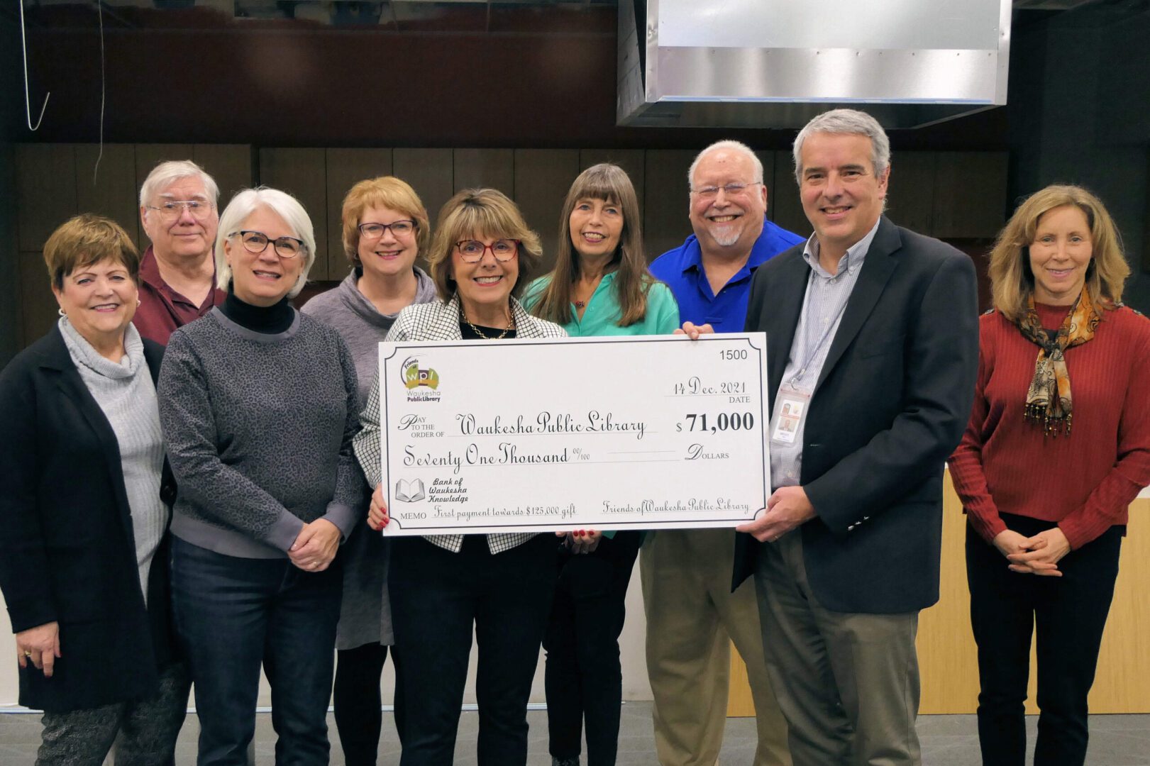 Group holding a large donation check.