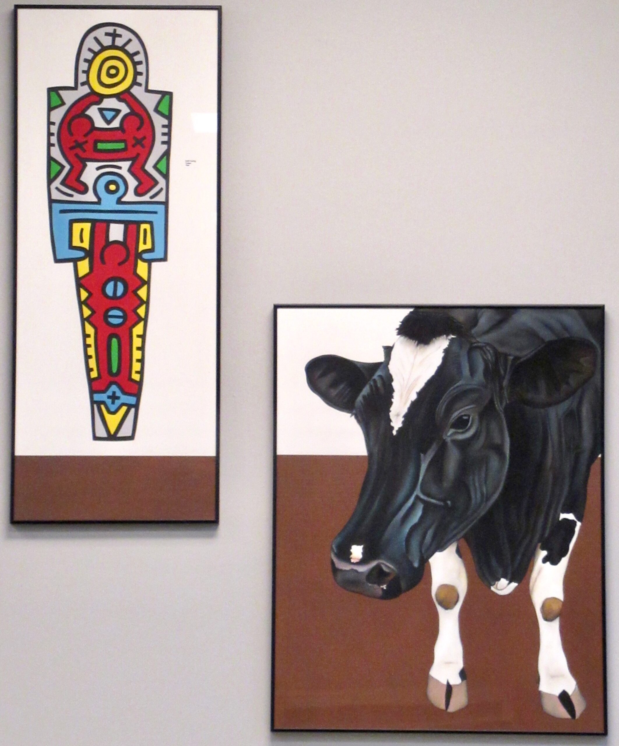 Chuck Wickler paintings. One pays homage to Keith Haring with figures and symbols and the other is a cow.